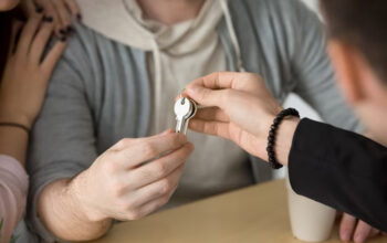 Person passing a key to another individual.