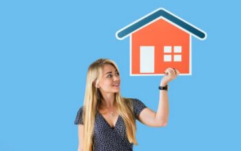 a cheerful young woman holding a cardboard house icon