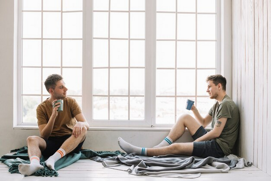 friends drinking coffee sitting near a window