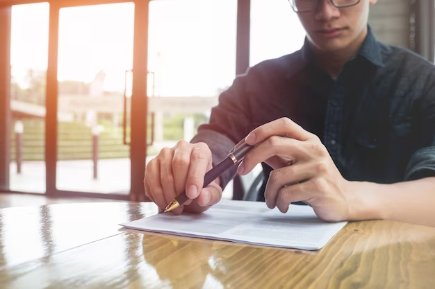 Man with a pen in front of documents